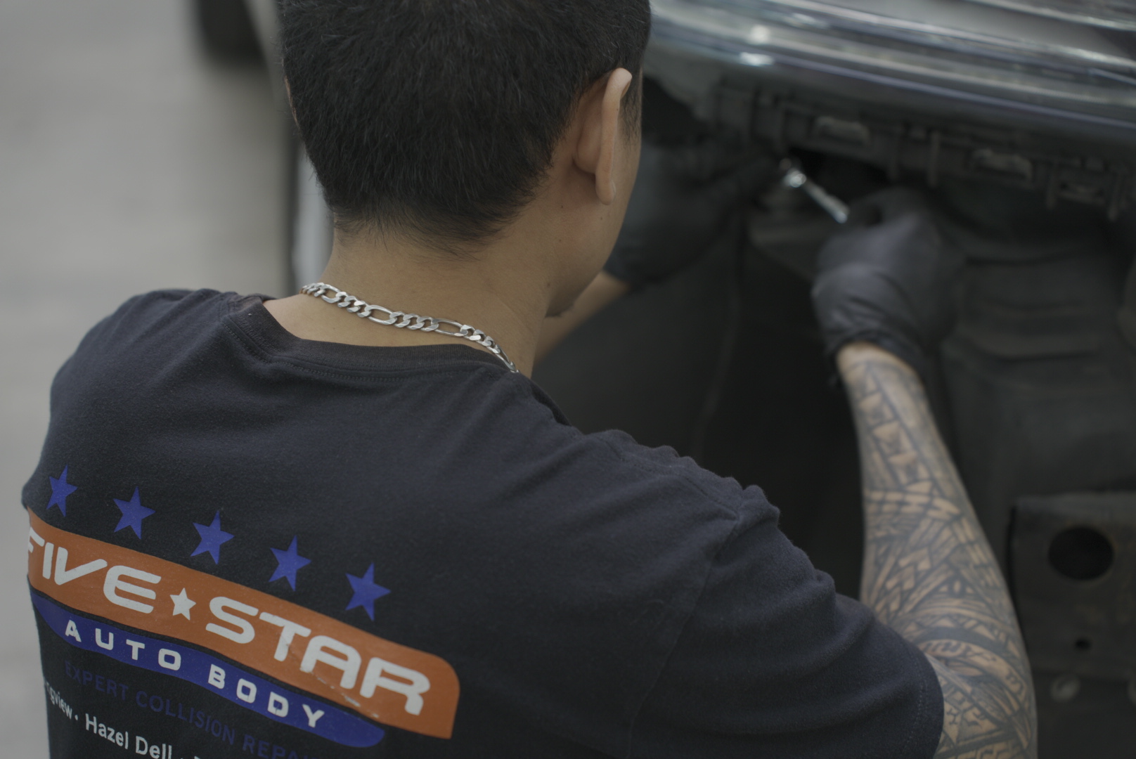 Professional paintless dent repair technician removing door ding at Five Star Auto Body in Vancouver WA
